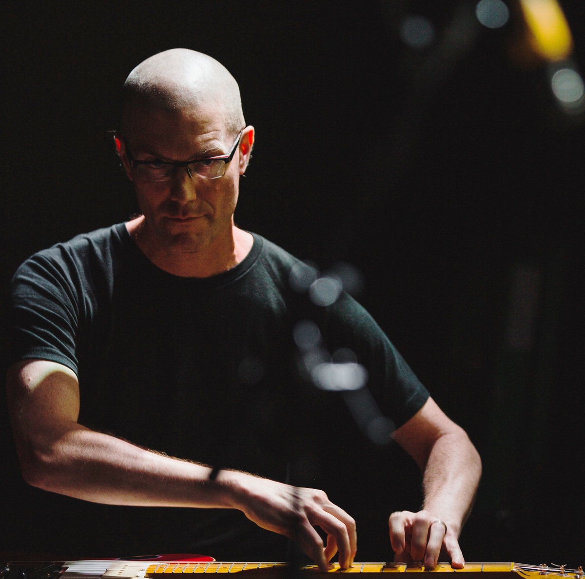 Christopher Burns playing electric guitar, photographed by Ben Semisch